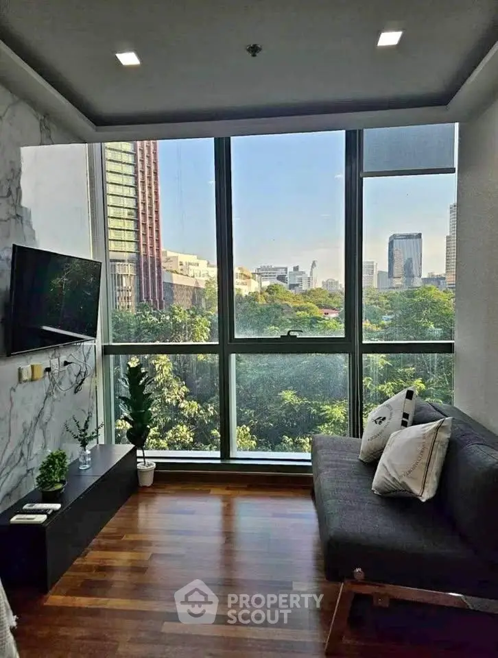 Modern living room with large windows offering stunning cityscape views and elegant decor.