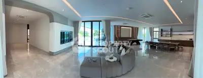 Luxurious open-plan living room with modern decor and expansive windows