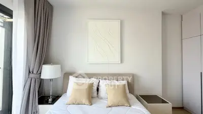 Modern bedroom with elegant decor and natural light, featuring a cozy bed and stylish furnishings.