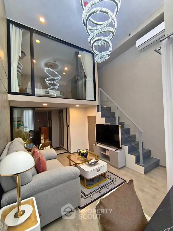 Luxurious modern living room with mezzanine and elegant chandelier lighting