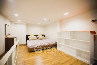 Spacious bedroom with modern decor and wooden flooring in a cozy apartment.