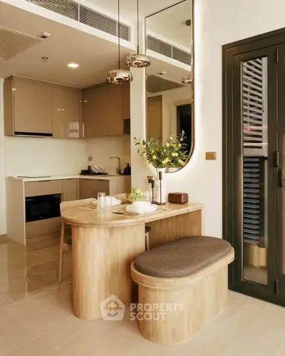 Modern kitchen with sleek cabinetry and cozy dining nook in stylish apartment.