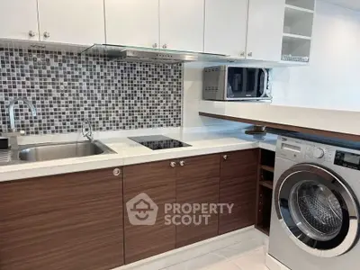 Modern kitchen with sleek cabinetry, built-in appliances, and stylish backsplash.