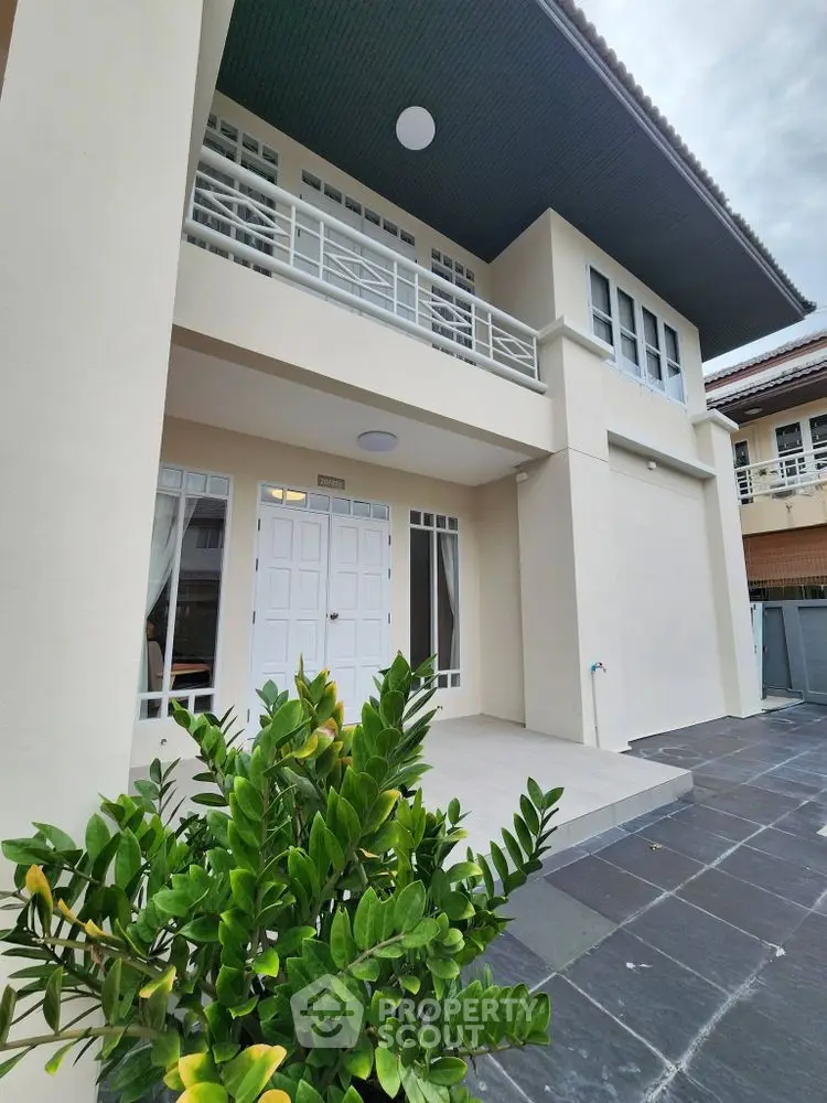Elegant two-story home with modern facade and lush greenery, perfect for family living.