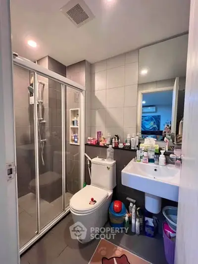 Modern bathroom with glass shower and sleek fixtures in a contemporary apartment.