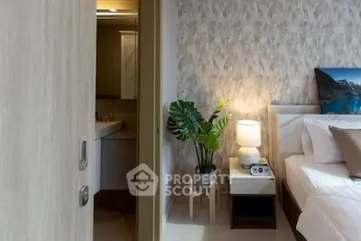 Cozy bedroom with modern decor and attached bathroom, featuring elegant wallpaper and ambient lighting.