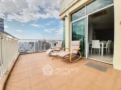 Spacious balcony with city skyline view and comfortable seating, perfect for relaxation.
