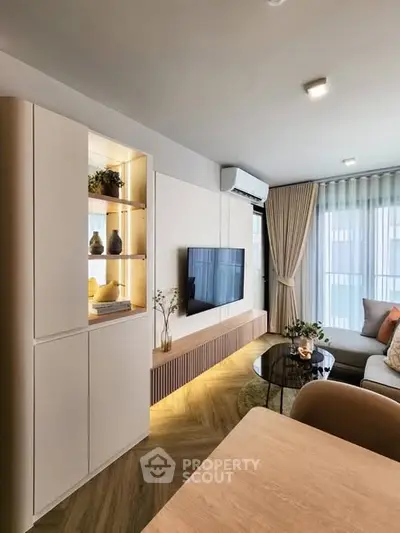 Modern living room with stylish decor, wall-mounted TV, and elegant lighting.