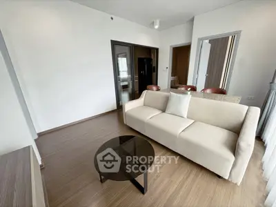 Modern living room with sleek furniture and open layout, featuring a comfortable sofa and stylish coffee table.