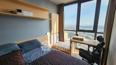 Modern bedroom with stunning city view, featuring sleek furniture and large windows for natural light.