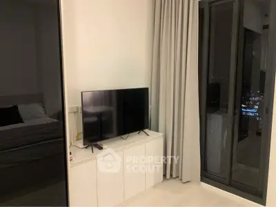 Modern bedroom with sleek TV setup and city view from window