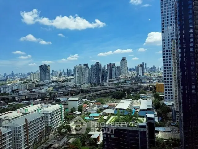 Stunning cityscape view from high-rise building showcasing urban skyline and blue sky.