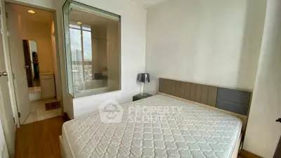 Modern bedroom with glass-enclosed bathroom and city view