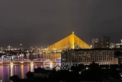 Stunning night view of city skyline with illuminated bridge and river reflections.