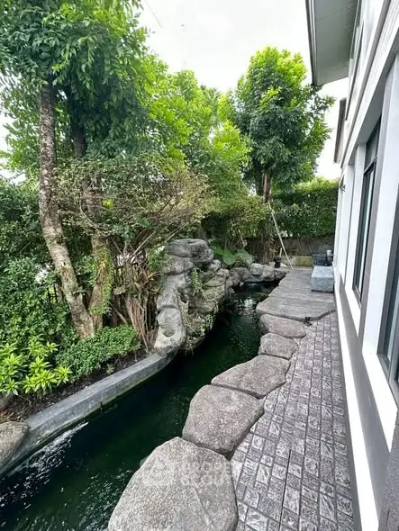 Serene garden view with lush greenery and stone pathway beside a modern building
