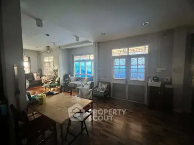 Charming living room with cozy seating and natural light, perfect for relaxation and entertaining.