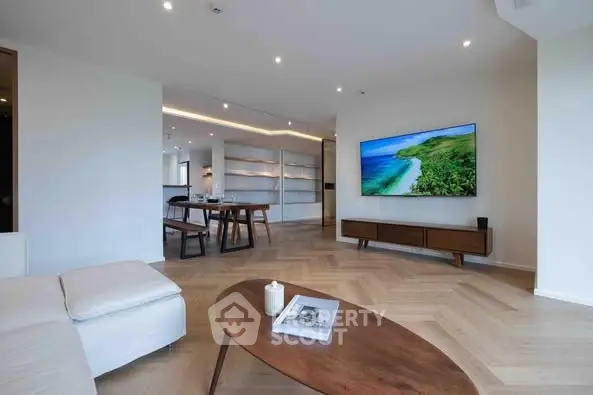 Modern living room with sleek design, wooden flooring, and large TV, perfect for relaxation.