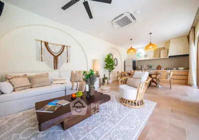 Spacious living room with open kitchen, stylish decor, and natural light in modern home.