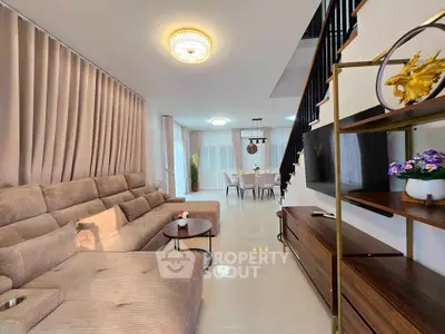 Spacious modern living room with elegant decor and open dining area, perfect for family gatherings.