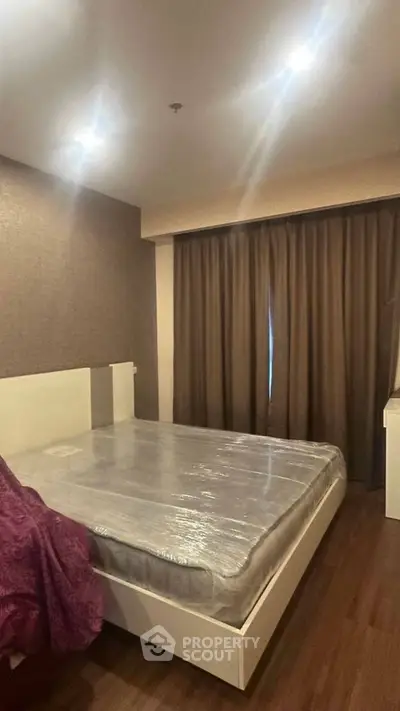Modern bedroom with sleek design and cozy ambiance, featuring a large bed and elegant curtains.