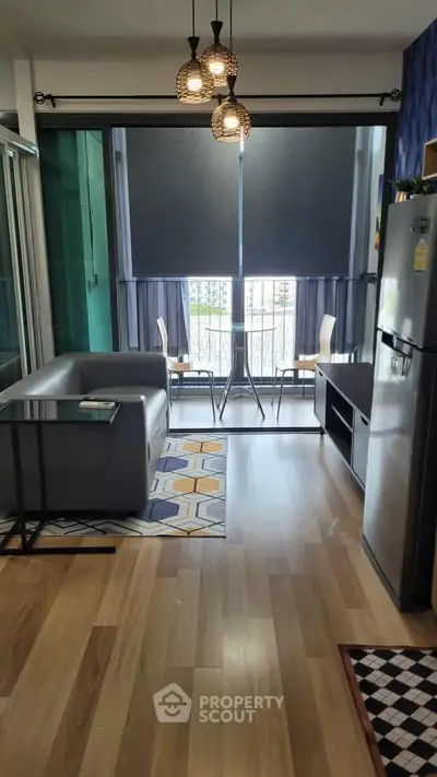 Modern living room with stylish decor and balcony view, featuring sleek furniture and natural light.