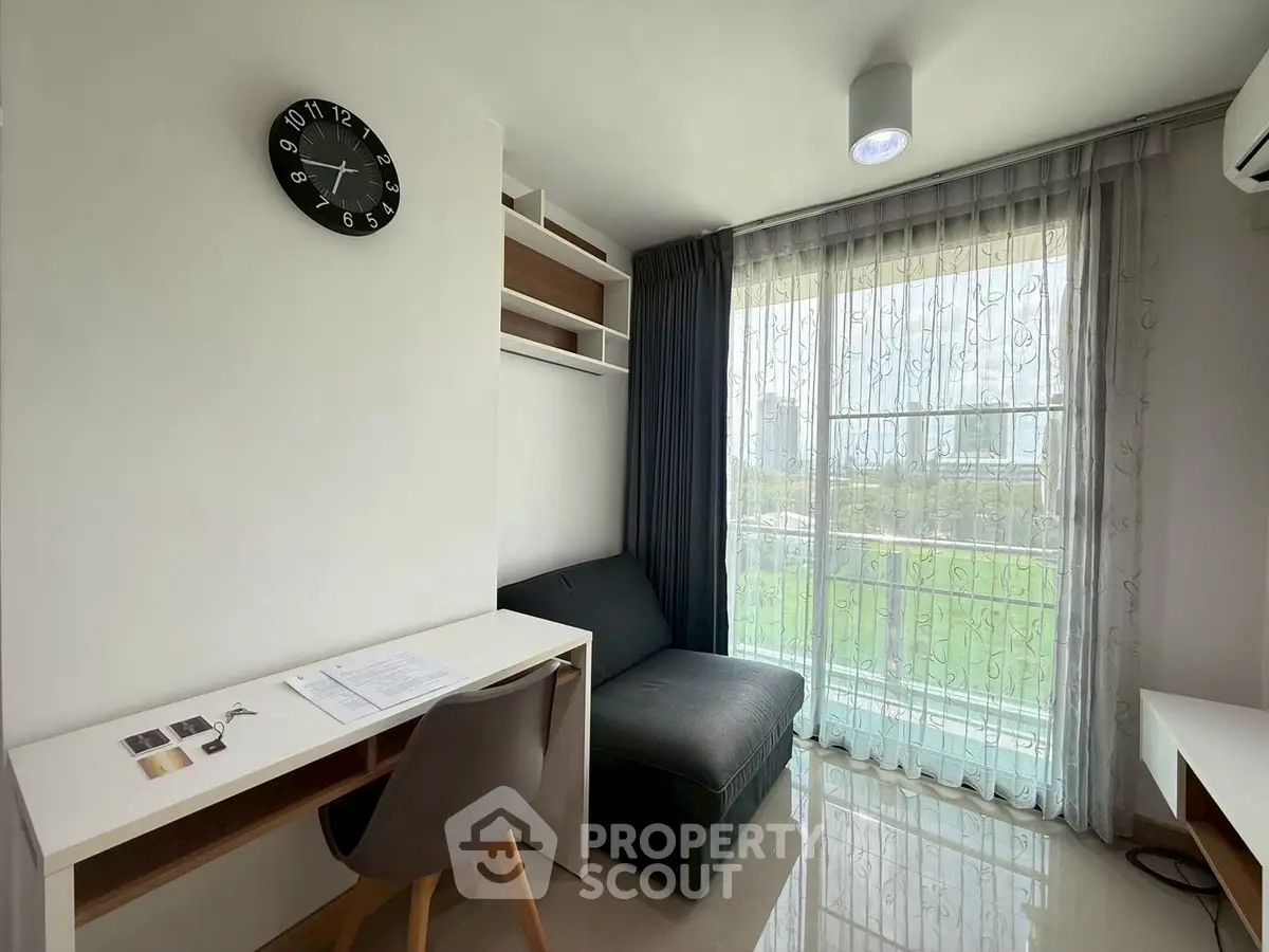 Modern study room with desk, chair, and sofa overlooking a scenic view through large windows.