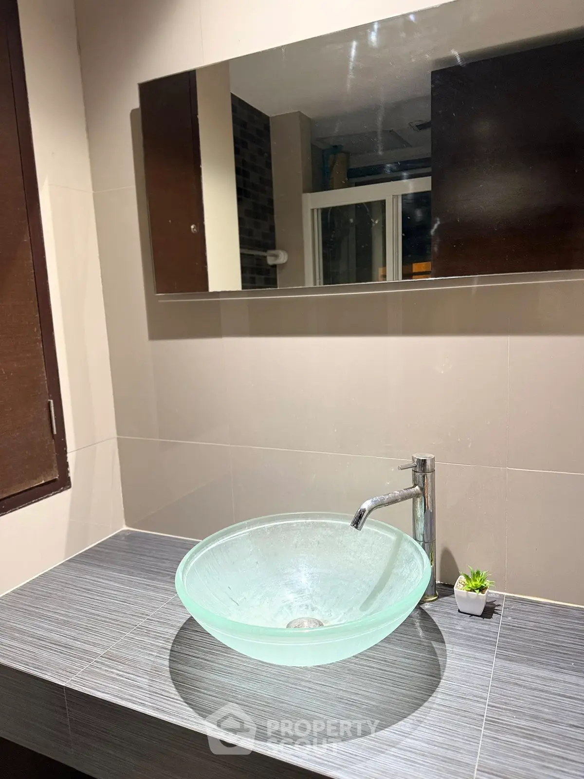 Modern bathroom with stylish glass sink and large mirror