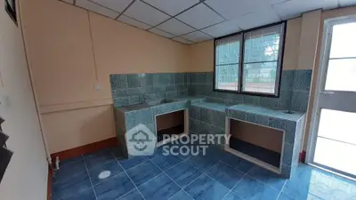 Spacious kitchen with tiled countertops and ample natural light