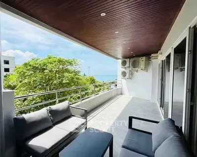 Spacious balcony with ocean view and modern outdoor seating, perfect for relaxation.