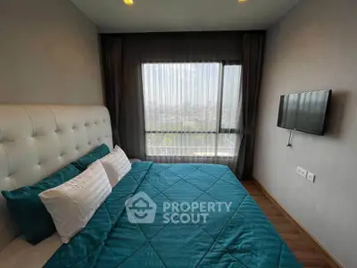 Modern bedroom with large window offering stunning city view, featuring stylish decor and wall-mounted TV.
