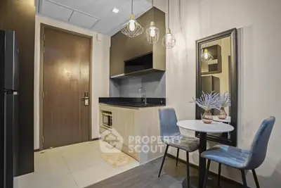 Modern compact kitchen with stylish dining area and elegant lighting in a cozy apartment.