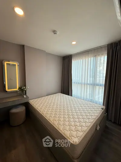 Modern bedroom with large window and stylish decor in a contemporary apartment.