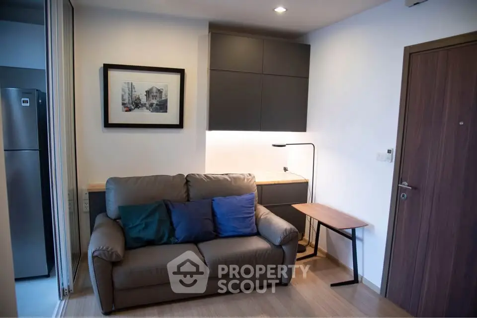 Cozy living room with modern sofa, stylish lighting, and framed artwork, perfect for urban living.