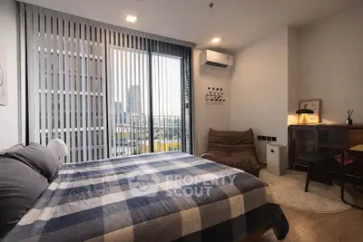 Modern bedroom with large window and city view, featuring stylish decor and cozy ambiance.