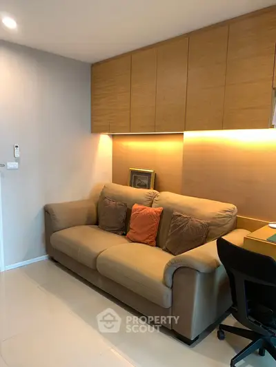 Cozy living room with plush sofa and modern lighting, perfect for relaxation.