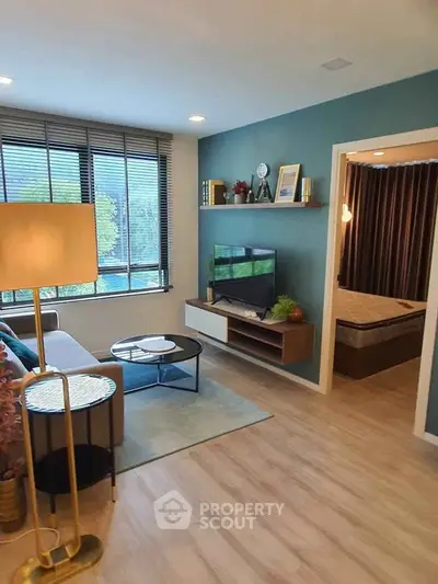 Modern living room with stylish decor and large window offering natural light.