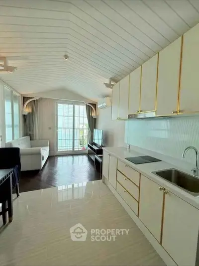 Elegant open-layout kitchen and living room with modern design and ample natural light.
