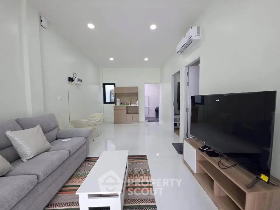 Modern living room with sleek furniture and large TV, perfect for relaxation.