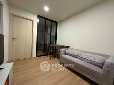 Modern living room with sleek furniture and wooden flooring in a cozy apartment.
