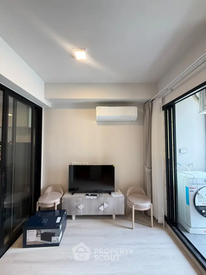 Modern living room with TV, air conditioning, and sliding glass doors
