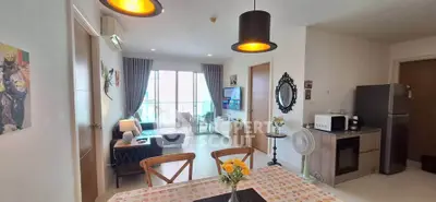 Modern open-plan living room with dining area and kitchen, featuring stylish decor and natural light.