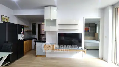 Modern open-plan living area with sleek kitchen and cozy bedroom view.