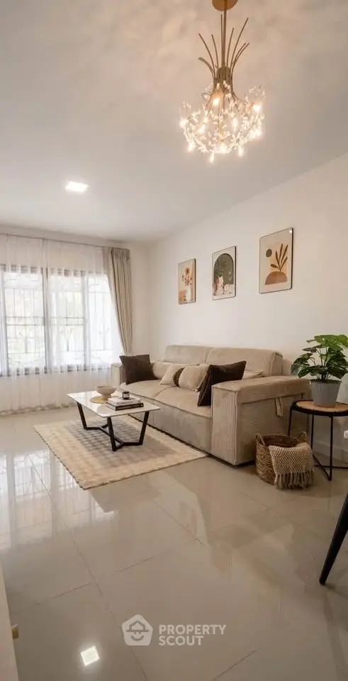 Elegant living room with modern chandelier, cozy sofa, and stylish decor in a bright, spacious setting.