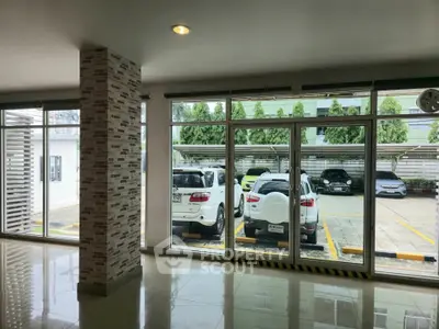 Spacious parking area view from modern building interior with large windows