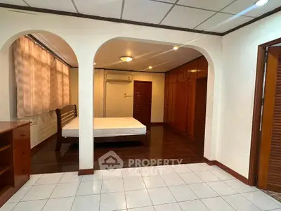 Spacious bedroom with wooden flooring and built-in wardrobes, perfect for comfortable living.