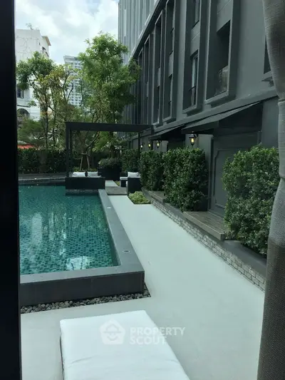 Luxurious modern apartment poolside with lush greenery and sleek design.