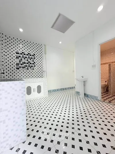 Spacious bathroom with modern black and white tile design and sleek fixtures.