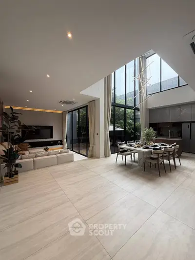 Luxurious open-plan living and dining area with high ceilings and modern decor