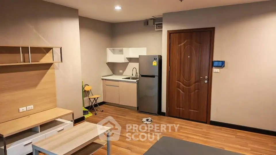 Modern studio apartment with compact kitchen and wooden flooring