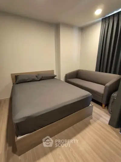 Modern bedroom with cozy bed and stylish sofa in a contemporary apartment.